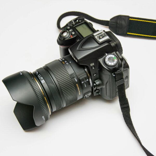 Close-up of a DSLR camera with a lens and strap, ideal for photography equipment themes.